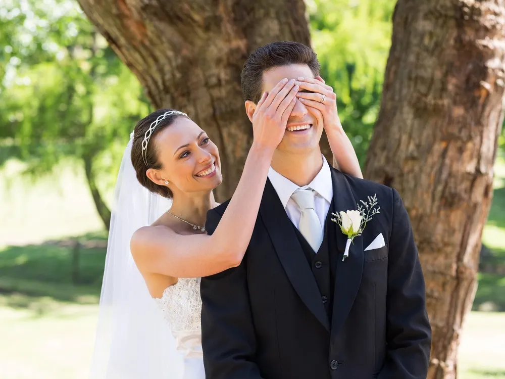 Stunning bride with hands over groom's eyes getting ready for first look at Kirkbrae Country Club