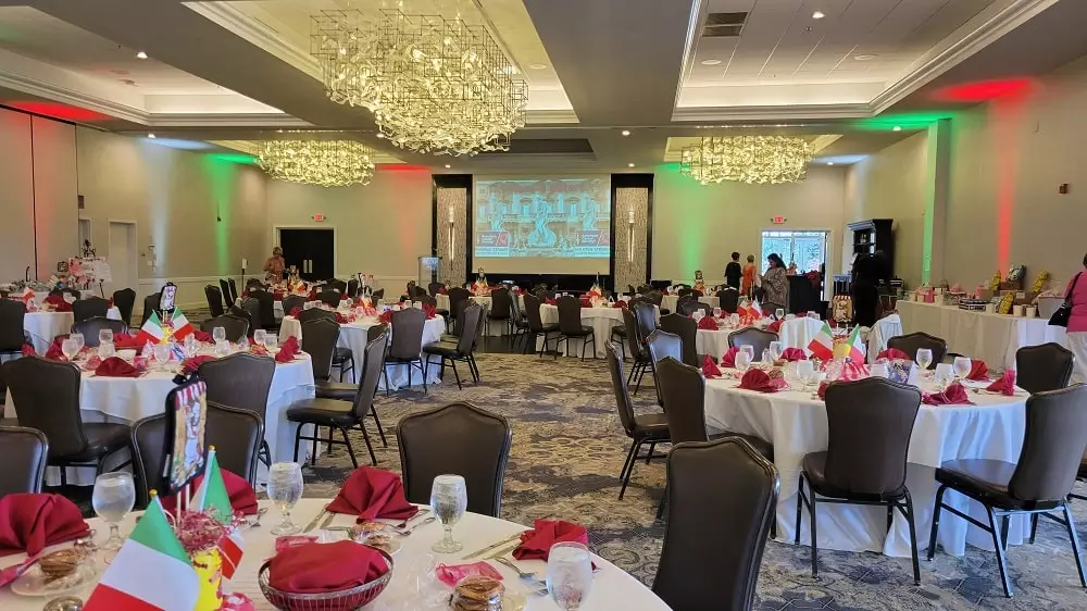 Indoor setup for corporate event with table setups and projector screens