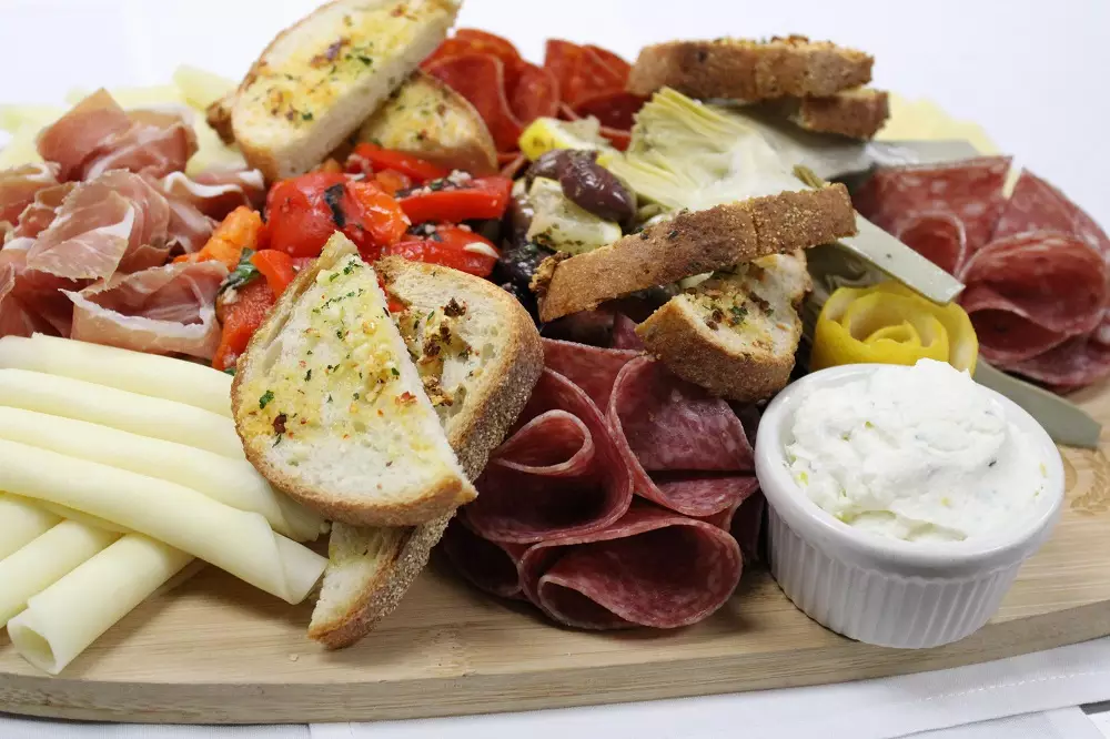 Charcuterie board with salted meats, cheeses, and olives