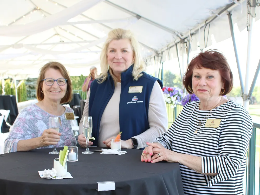 3 women with nametags having a conversation at hte Kirkbrae outdoor tented patio space