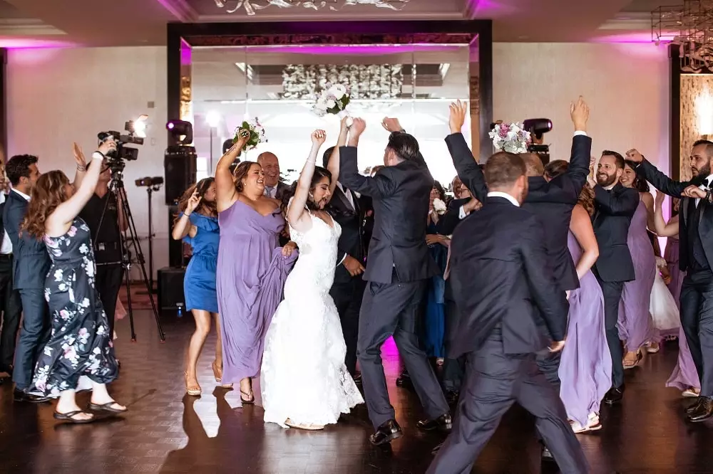Bride and groom dancing with guests on dancefloor