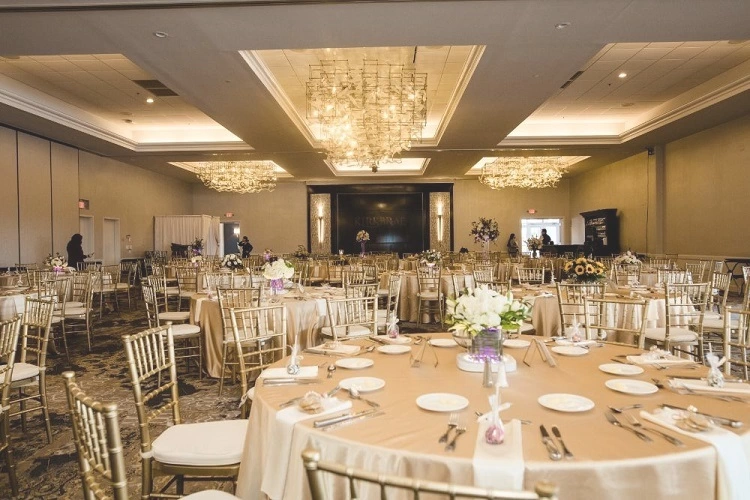 Wedding tables setup in grand ballroom under chandelier