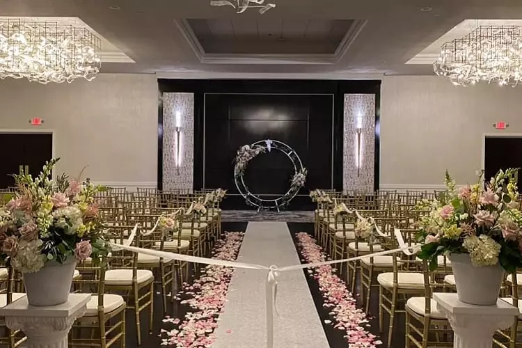 beautifully decorated event function with gold tapestries and pink rose petals on walkway