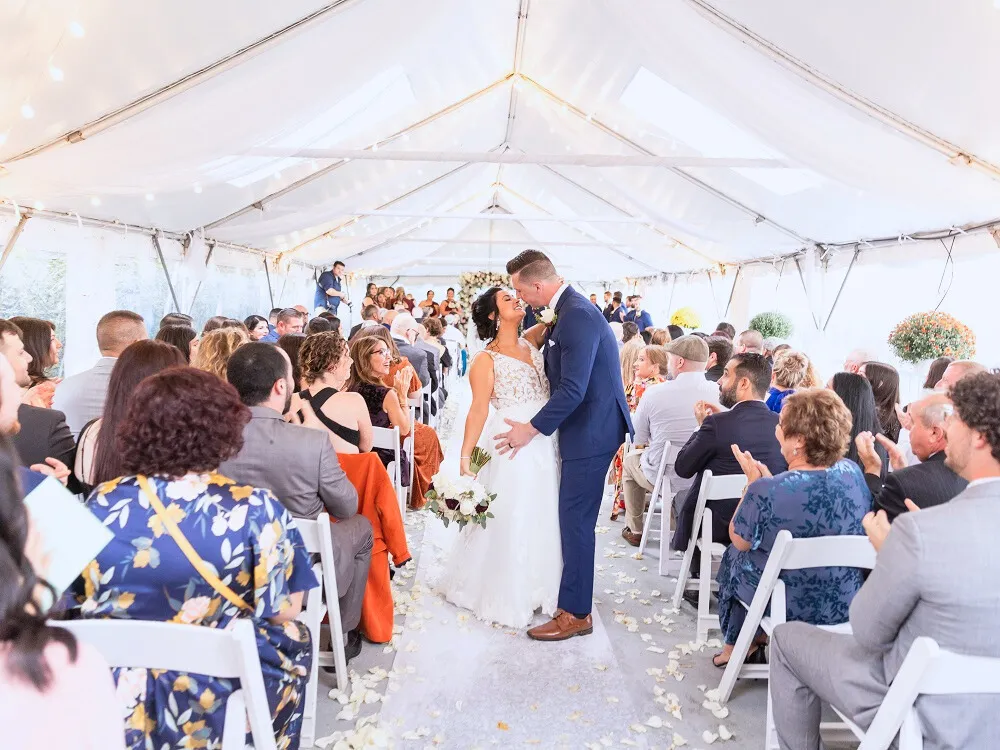 Bride and groom in the outdoor tented patio with everyone cheering