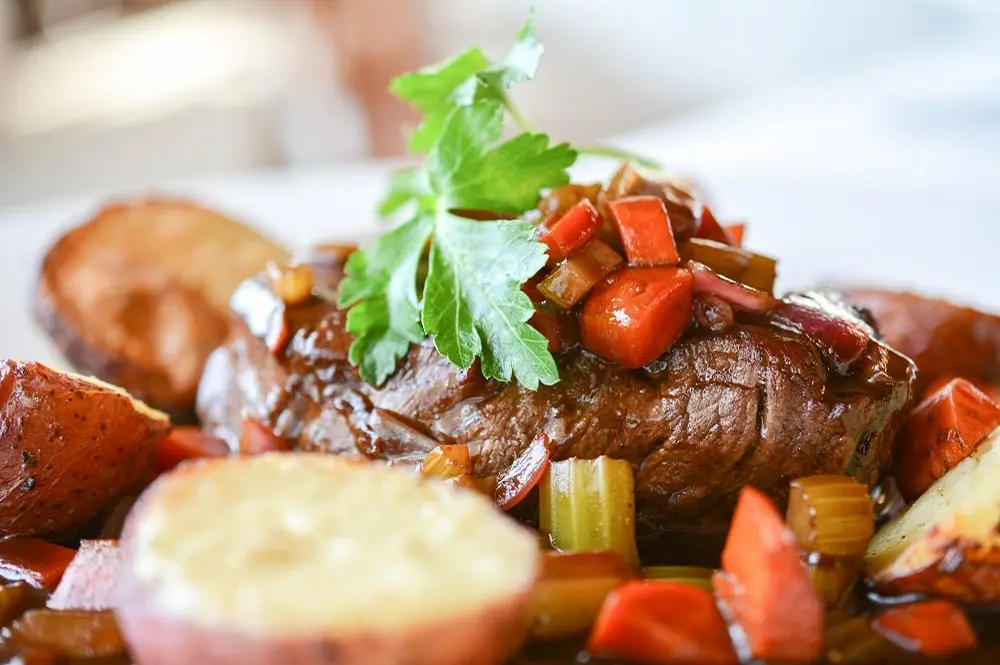 Delicious looking grilled steak topped with tomato and basil