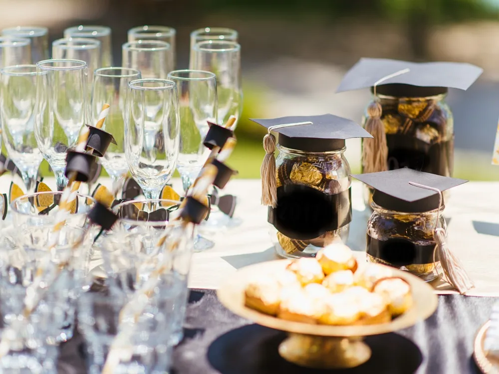 Decorated table with streamers and colorful balloons for an outdoor graduation party