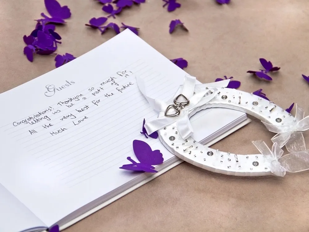 Purple and white ribbon decorated wedding guest book