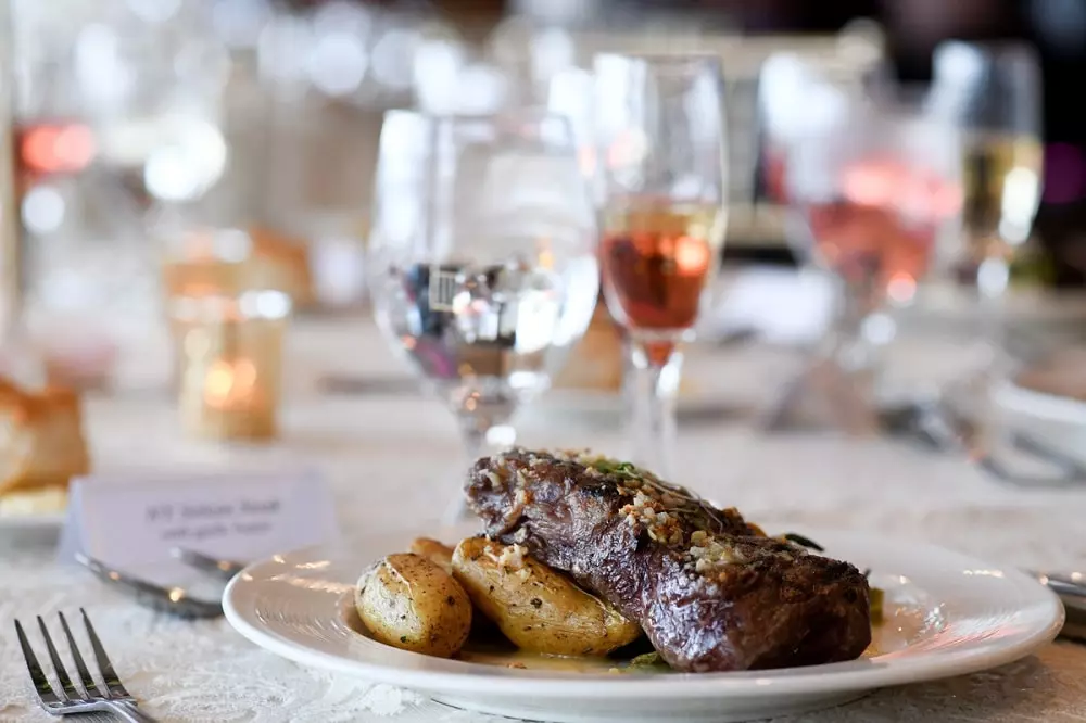 Fine wedding cuisine of ribeye steak and fingerling potatoes with a glass of wine